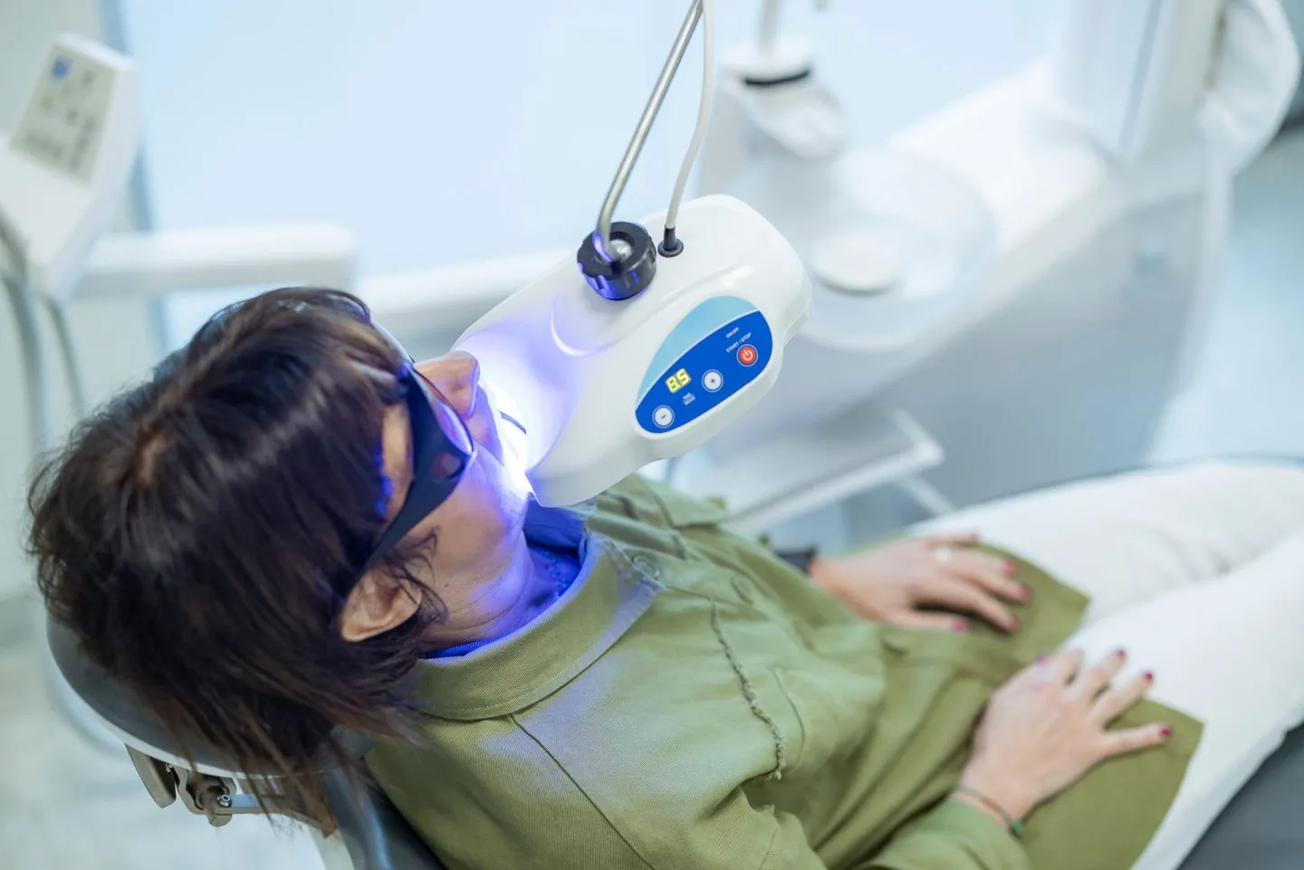 Una paziente viene sottoposta al trattamento con la lampada sbiancante presso lo Studio Redolfi, dentista a Flero e Brescia