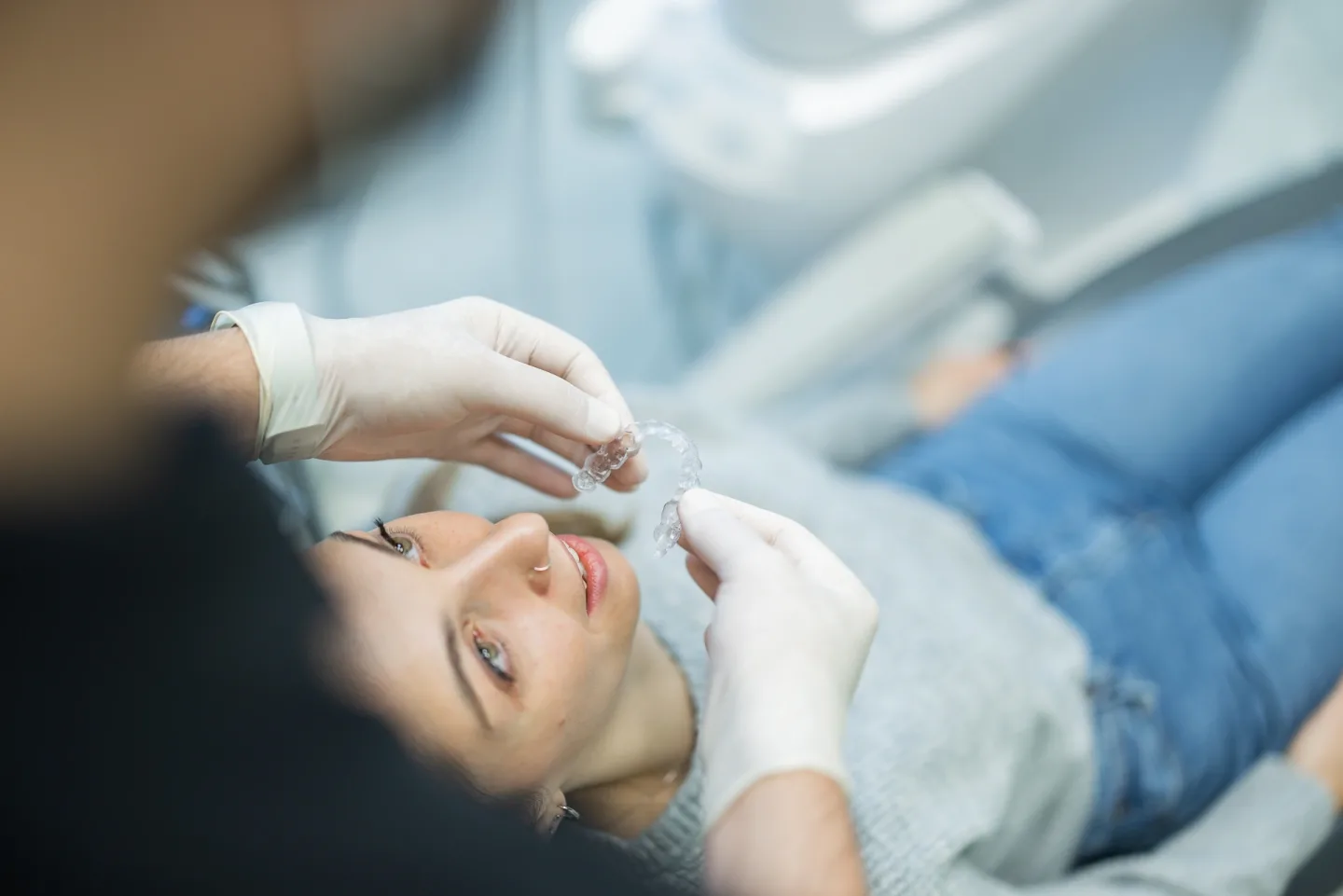 Un dottore applica una mascherina trasparente rimovibile ad un paziente presso lo studio Redolfi, dentista a Flero e Brescia